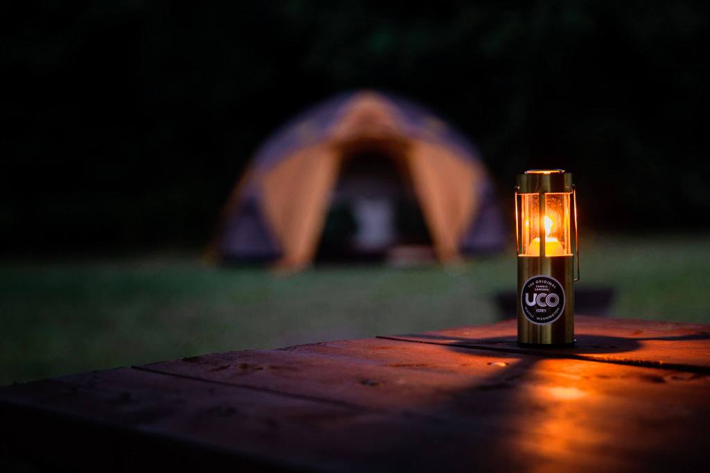UCO Original candle lantern on a picnic table at night