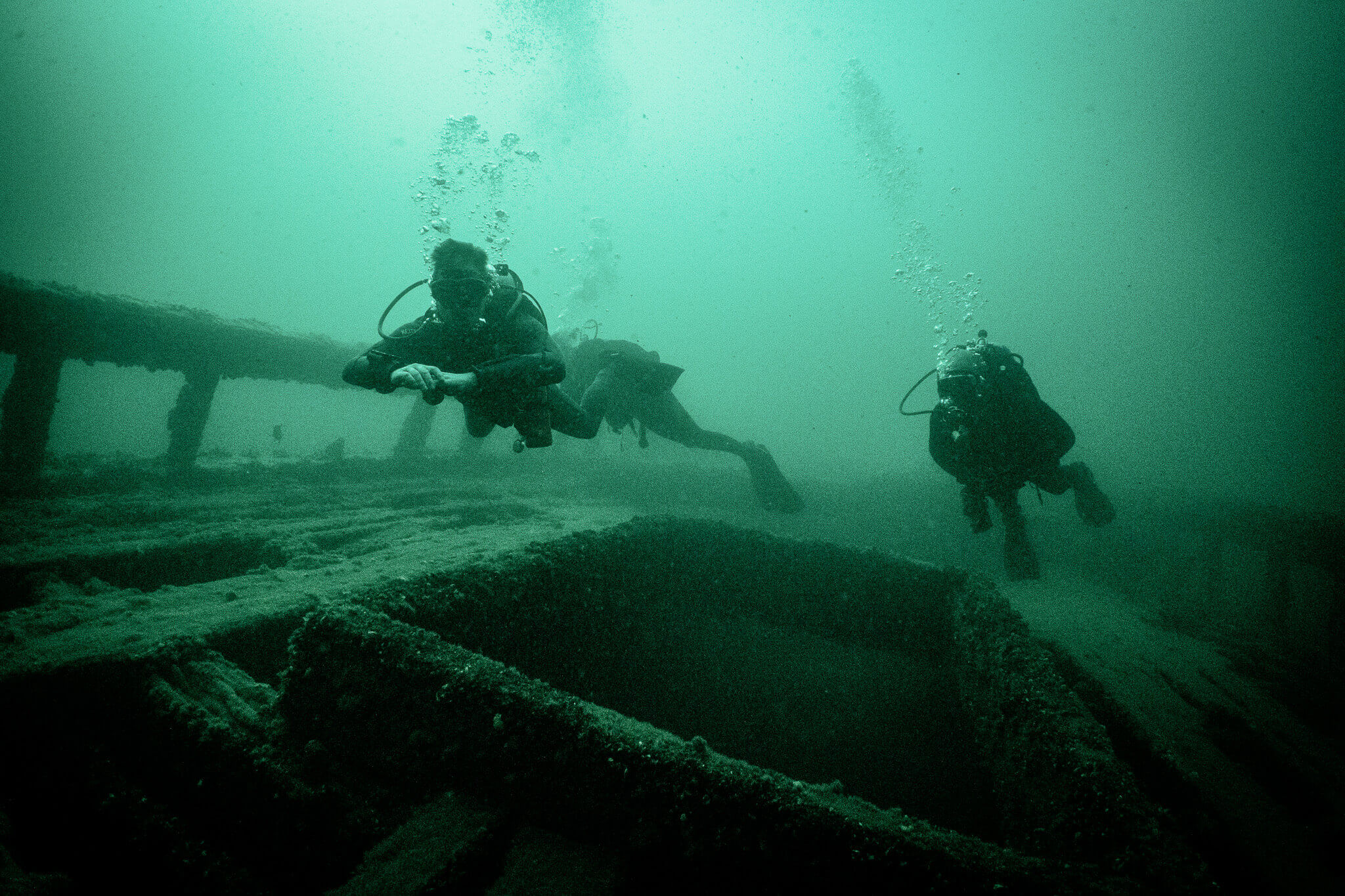 Underwater photo of scuba divers swimming over the A.E. Vickery shipwreck