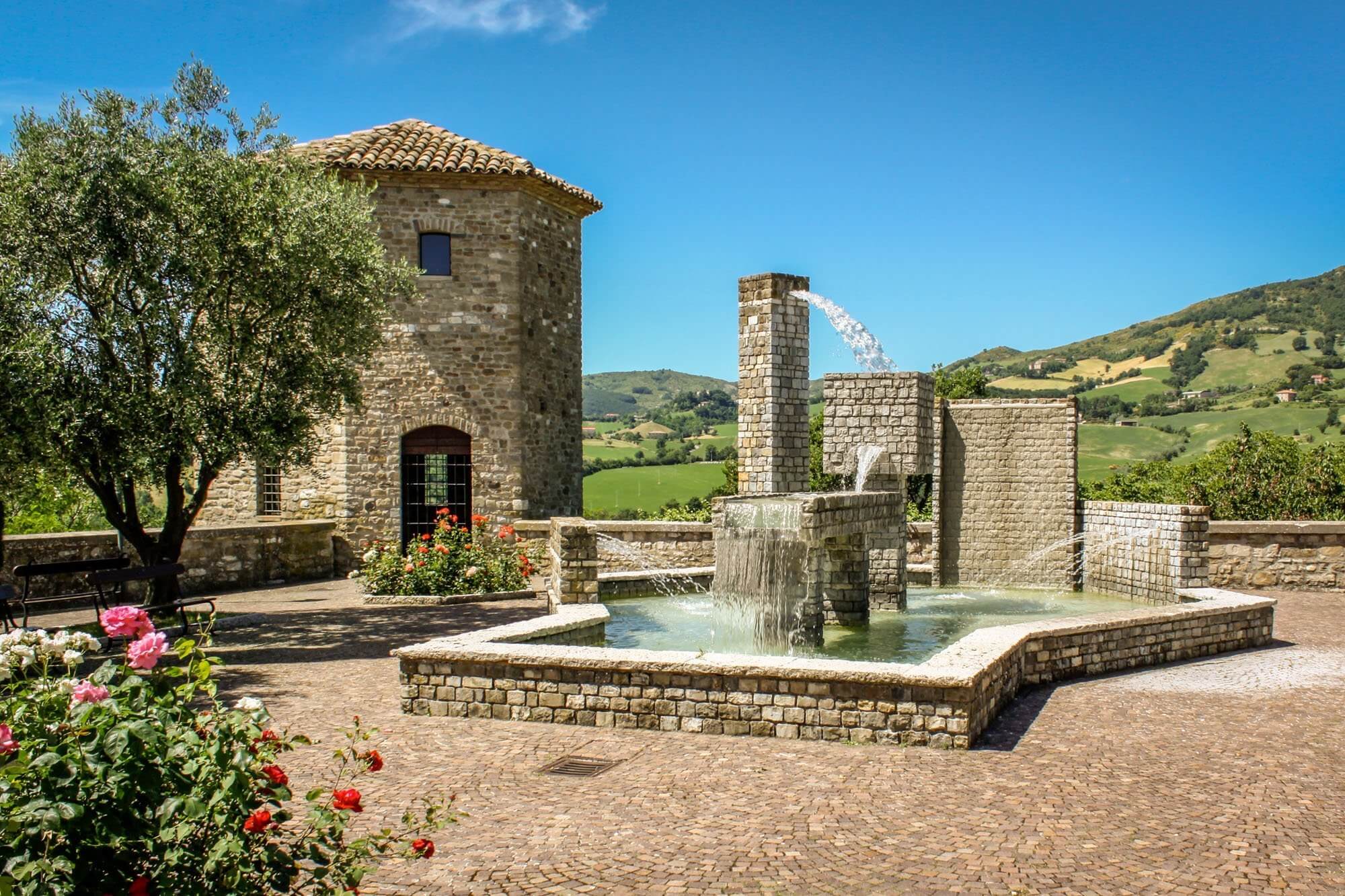 The Medieval watchtower and modern fountain in Piazza Leopardi in Frontone