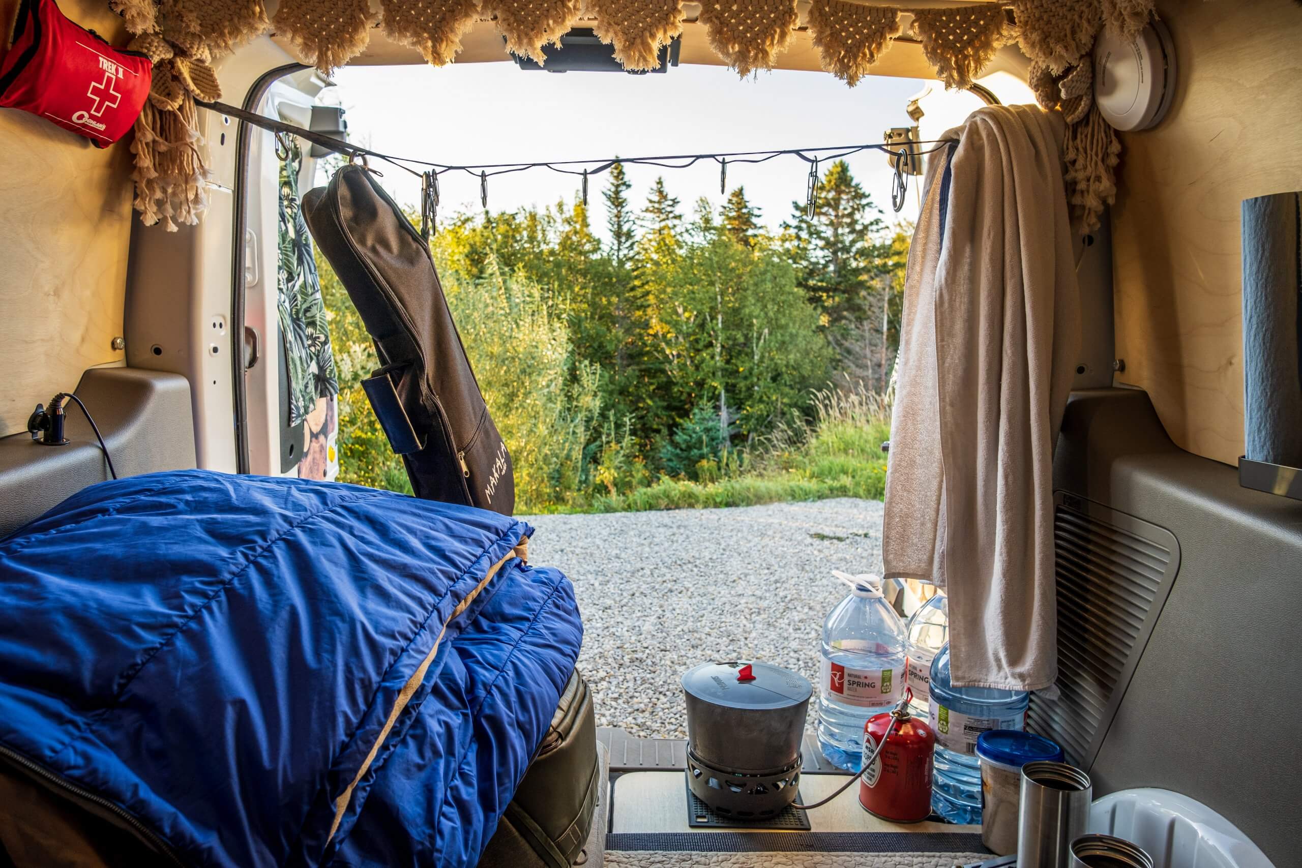 The interior of a Ford Transit Connect camper van conversion with rear doors open