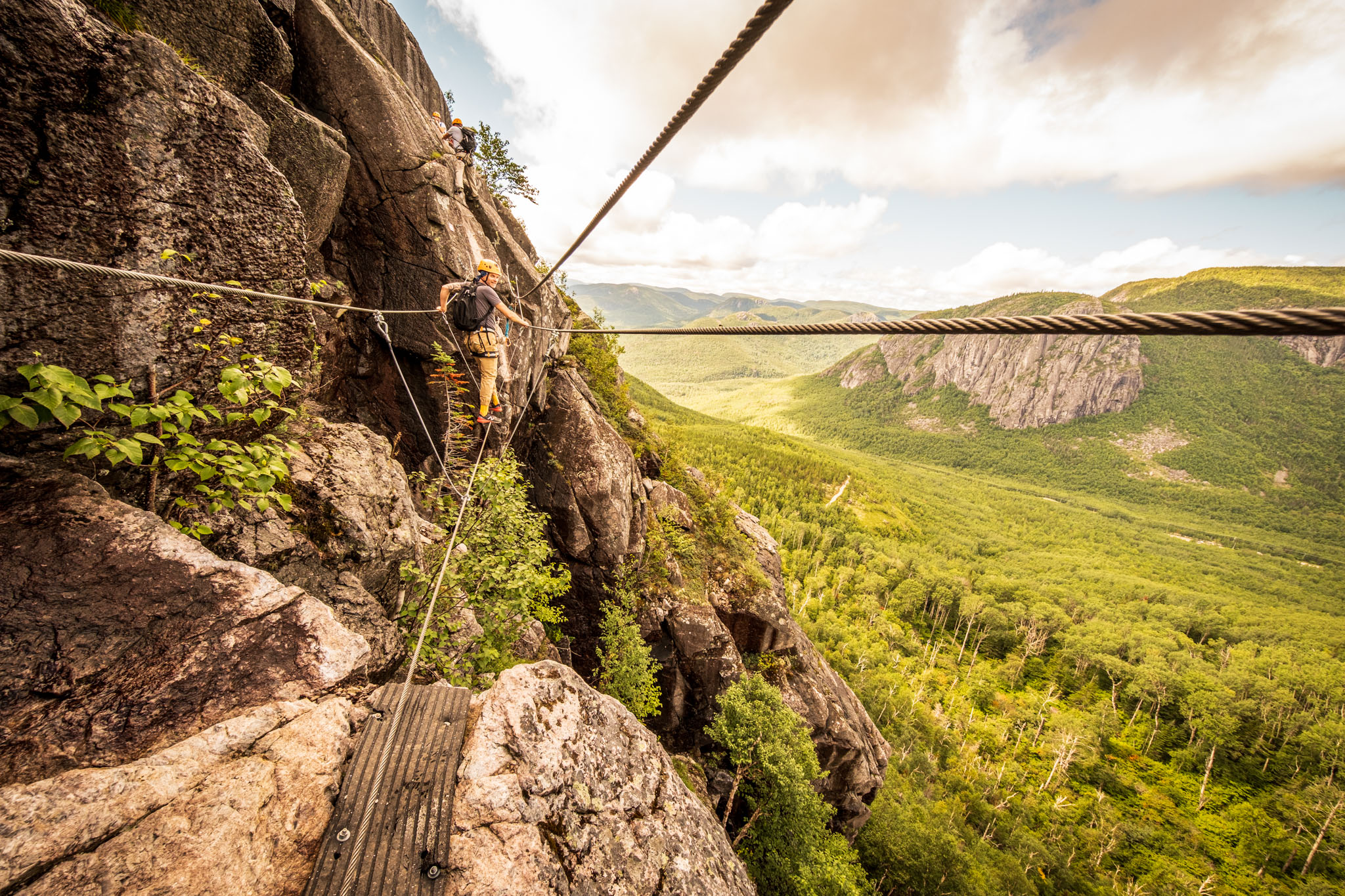Via ferrata climber crossing a cable bridge at Parc national des Grands-Jardins