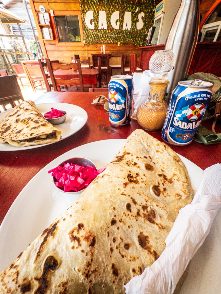 Two plates with baleadas and Salva Vida beer at Gaga’s Grab-n-go in Utila