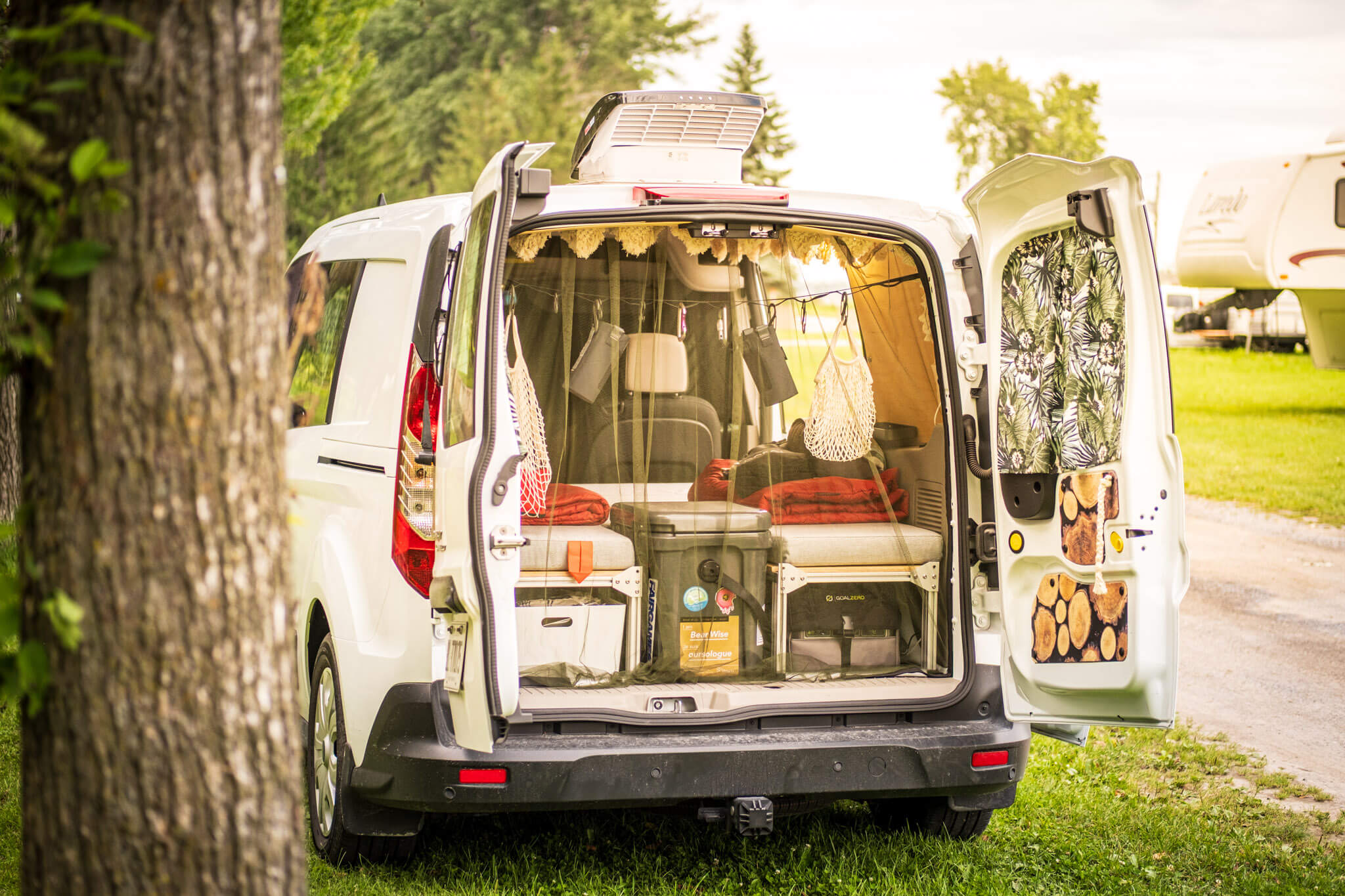 Looking through the rear doors of a Ford Transit Connect camper van conversion on a road trip