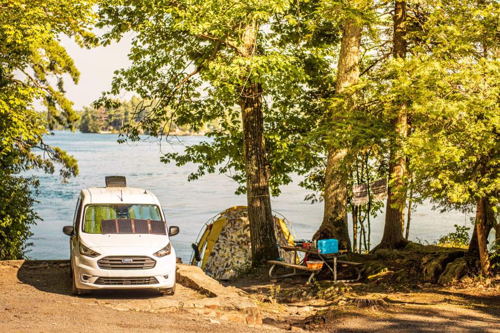 Transit Connect camper van in front of the St. Lawrence River at Ivy Lea Campground