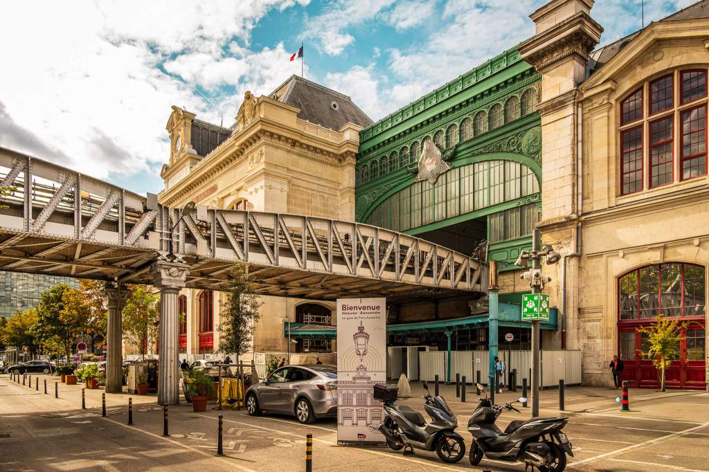 The exterior of Gare d'Austerlitz in Paris, showing a raised train platform entering the building