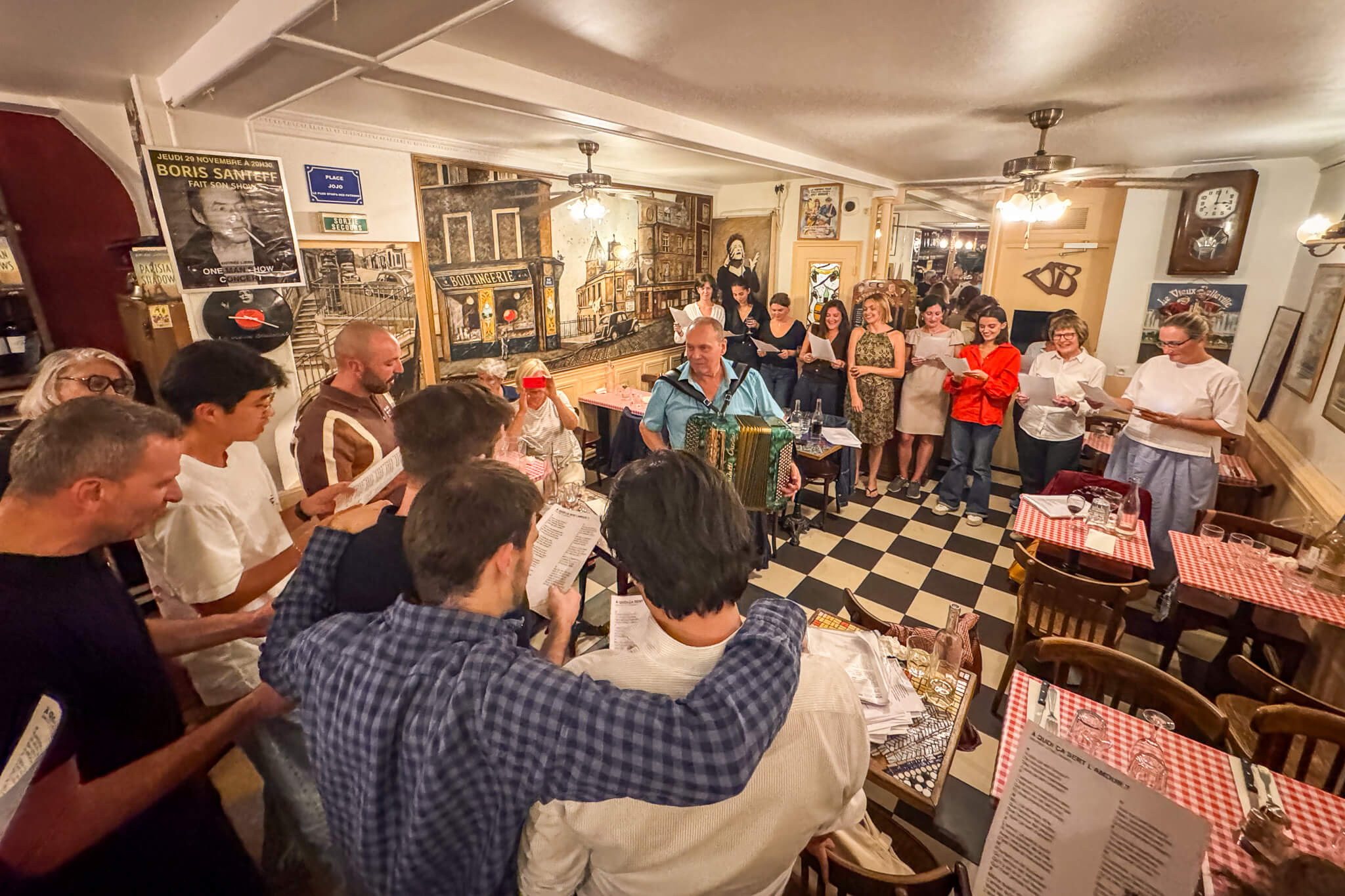 Guests singing along to Edith Piaf songs at Le Vieux Belleville restaurant in Paris
